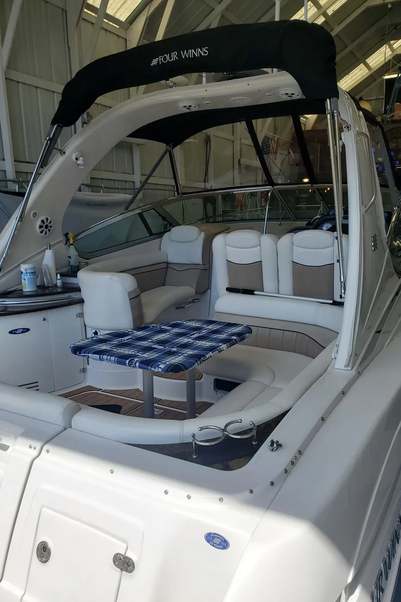 Slide: The Image of 2006 Four Winns 350 boat interior with seating and table, docked in a marina. - 8