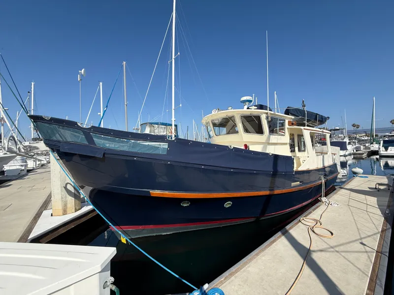 The Image of 1978 Fisher 38 Trawler docked at marina under clear blue sky. - 0