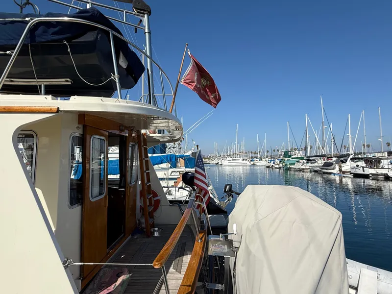 Slide: The Image of 1978 Fisher 38 Trawler docked in a marina, surrounded by sailboats under a clear blue sky. - 10