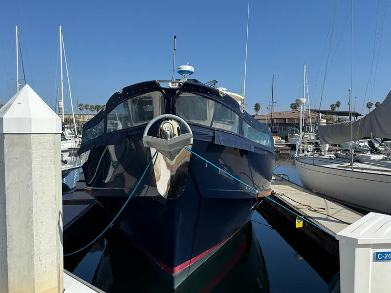 Slide: The Image of 1978 Fisher 38 Trawler docked at marina, front view, clear blue sky. - 16