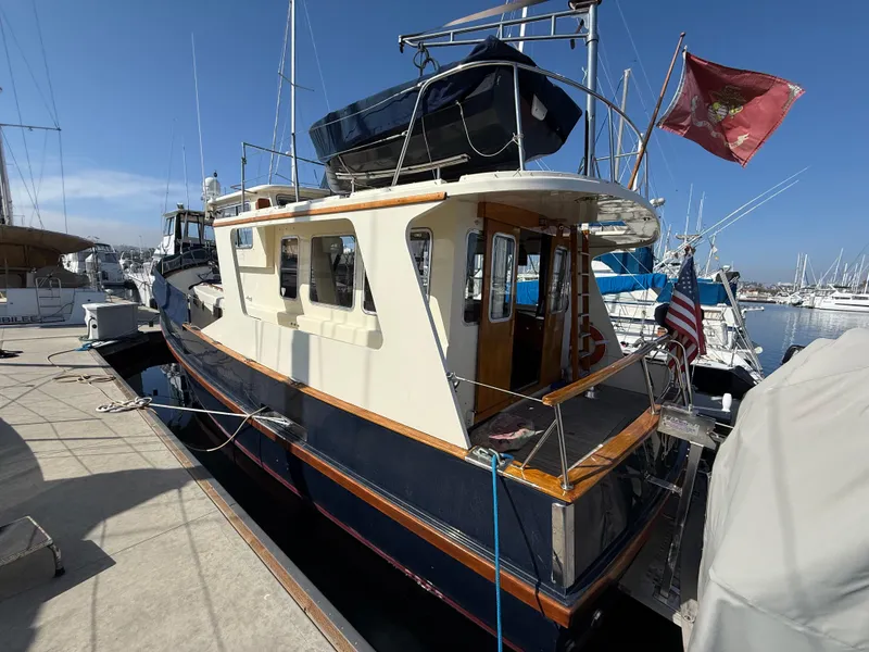 Slide: The Image of 1978 Fisher 38 Trawler docked at marina, featuring classic design and flags. - 2