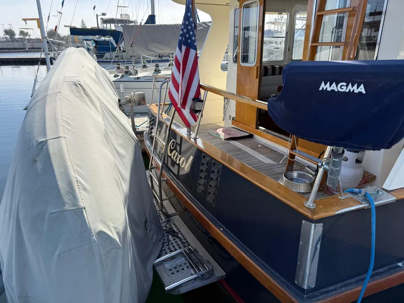 Slide: The Image of 1978 Fisher 38 Trawler docked, featuring American flag and covered equipment. - 20