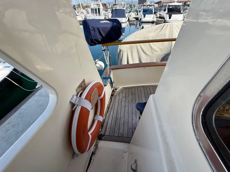 Slide: The Image of 1978 Fisher 38 Trawler deck with life preserver, docked at marina. - 21