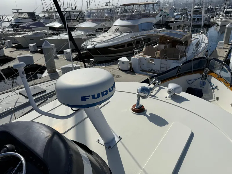 Slide: The Image of 1978 Fisher 38 Trawler with radar, docked among other boats in a marina. - 25