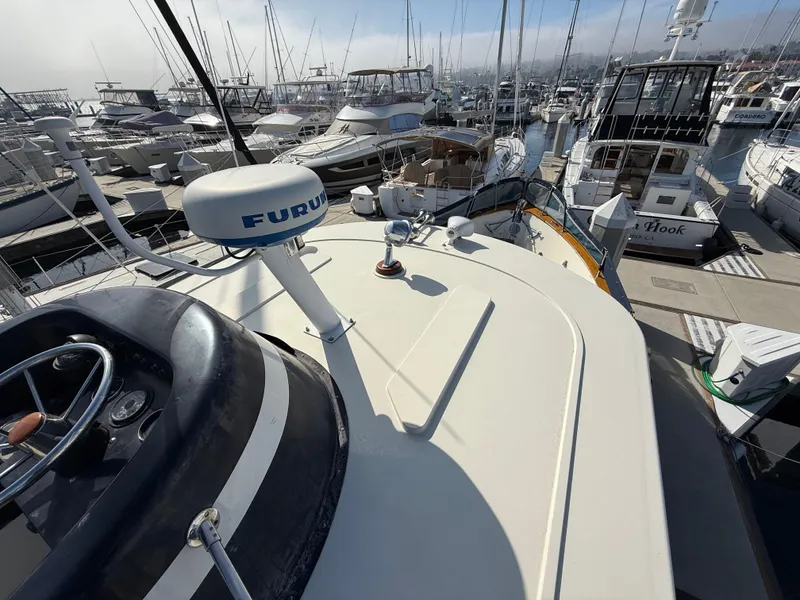 Slide: The Image of 1978 Fisher 38 Trawler docked in a busy marina, featuring navigation equipment. - 27