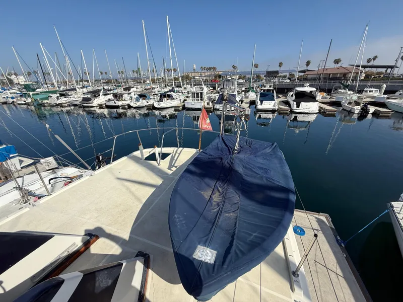 Slide: The Image of 1978 Fisher 38 Trawler docked in a marina, surrounded by sailboats and calm water. - 29
