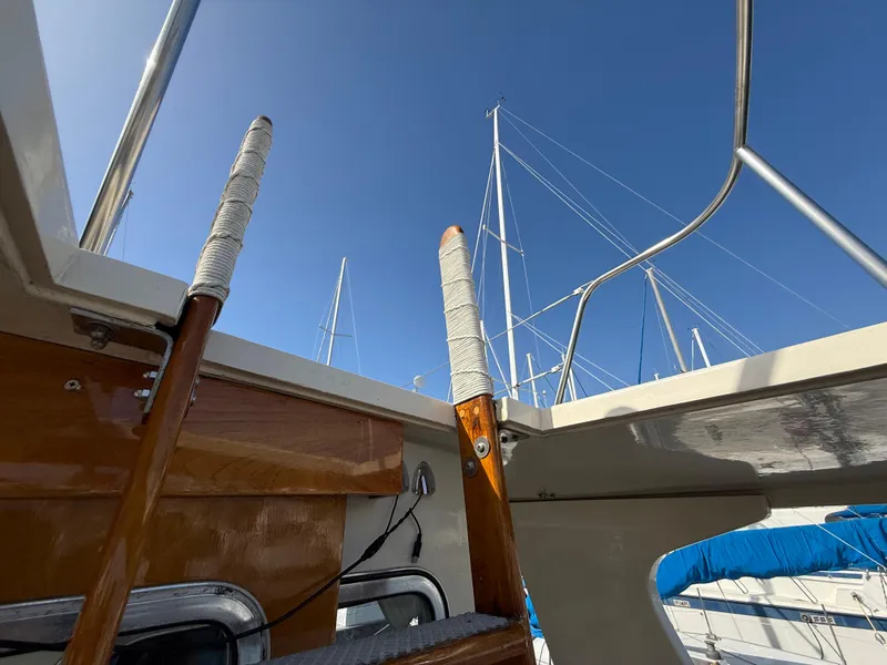 Slide: The Image of 1978 Fisher 38 Trawler deck view with wooden railings and clear blue sky. - 35