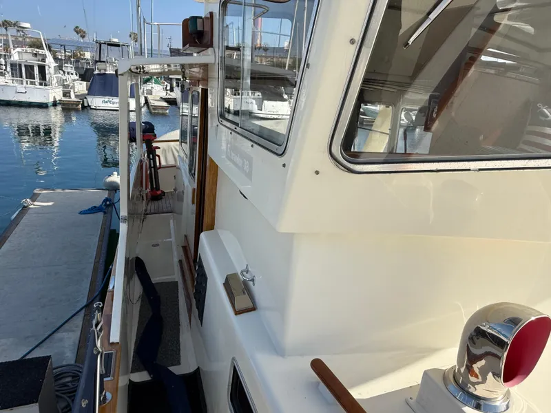 Slide: The Image of 1978 Fisher 38 Trawler docked at marina, showcasing side deck and cabin details. - 37
