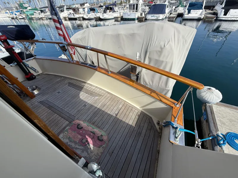 Slide: The Image of 1978 Fisher 38 Trawler deck with wooden railings, docked at a marina. - 38