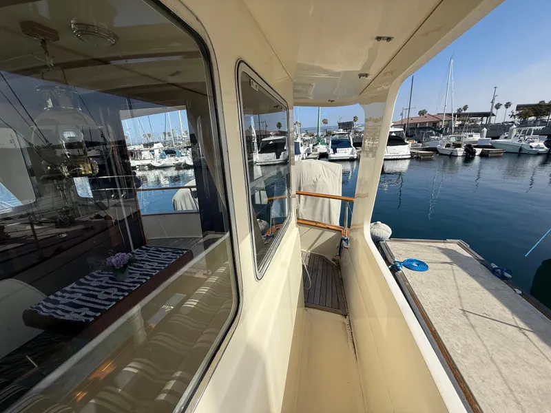 Slide: The Image of 1978 Fisher 38 Trawler docked at marina, showcasing side deck and cabin windows. - 39