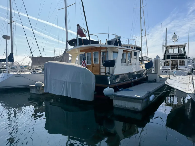 Slide: The Image of 1978 Fisher 38 Trawler docked at marina, surrounded by sailboats. - 4
