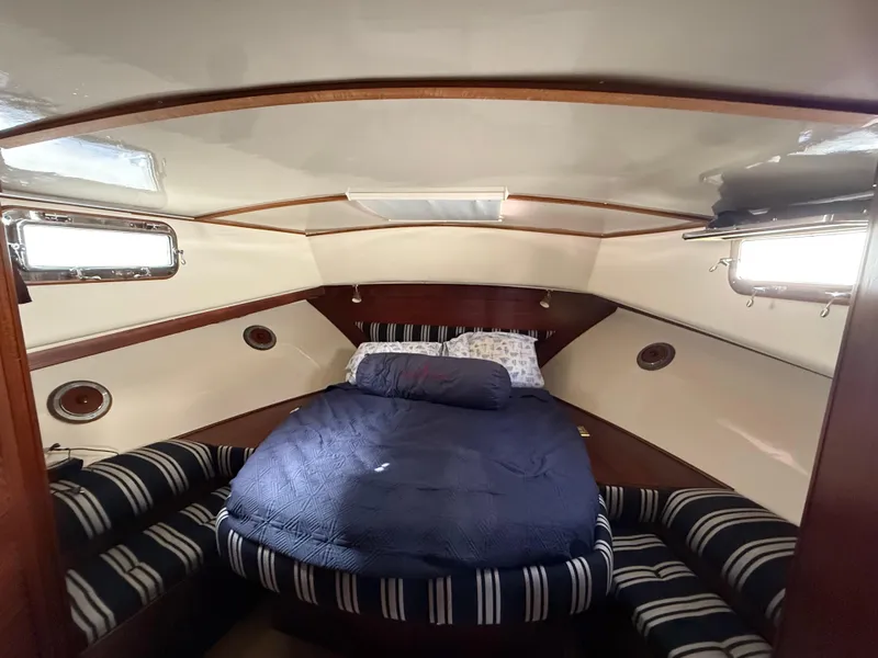 Slide: The Image of Cozy cabin interior of 1978 Fisher 38 Trawler with bed and striped seating. - 48