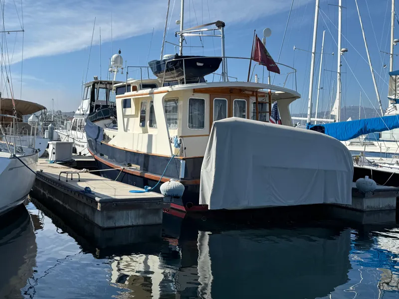 Slide: The Image of 1978 Fisher 38 Trawler docked at marina, covered stern, calm water reflections. - 5
