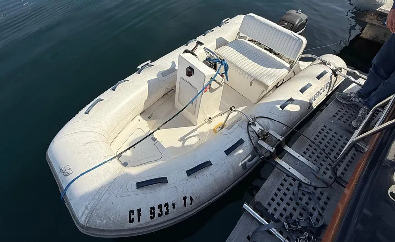Slide: The Image of Inflatable boat docked beside a Fisher 38 Trawler, 1978 model, on calm water. - 6