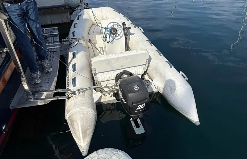 Slide: The Image of Inflatable boat with outboard motor docked beside Fisher 38 Trawler, 1978 model. - 7