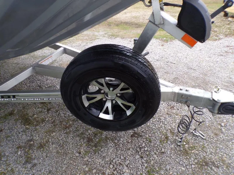 Slide: The Image of 2025 Xpress SW20B boat trailer with black alloy wheel on gravel surface. - 18