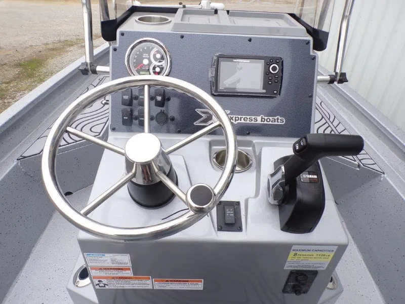 Slide: The Image of 2025 Xpress SW20B boat console with steering wheel, controls, and navigation display. - 31