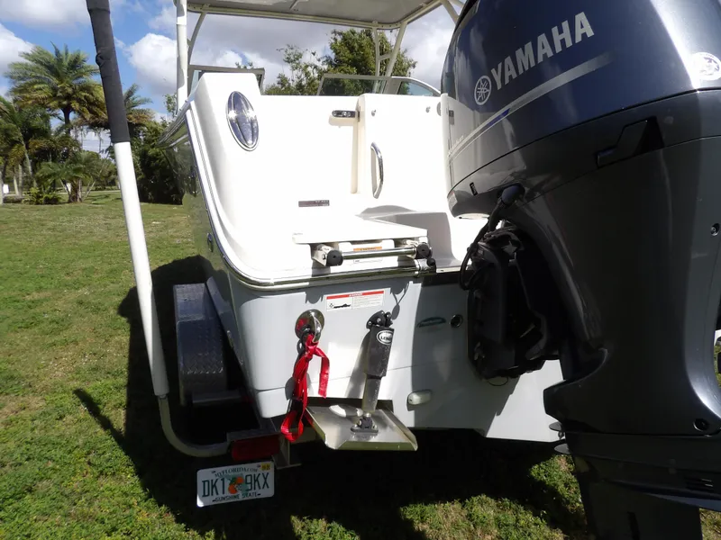 Slide: The Image of 2020 Sailfish 275 DC boat with Yamaha engine, parked on grass. - 12