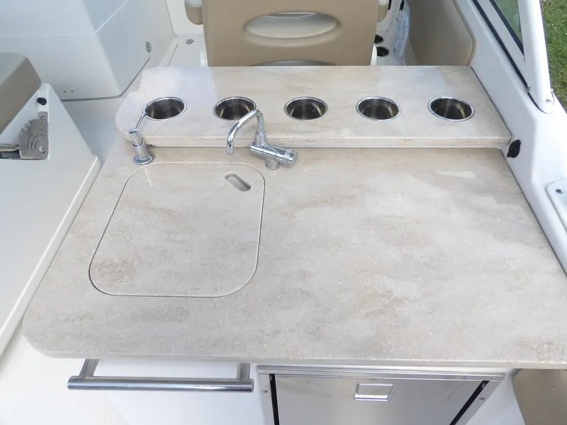 Slide: The Image of Sailfish 275 DC 2020 boat kitchenette with sink and cup holders. - 29