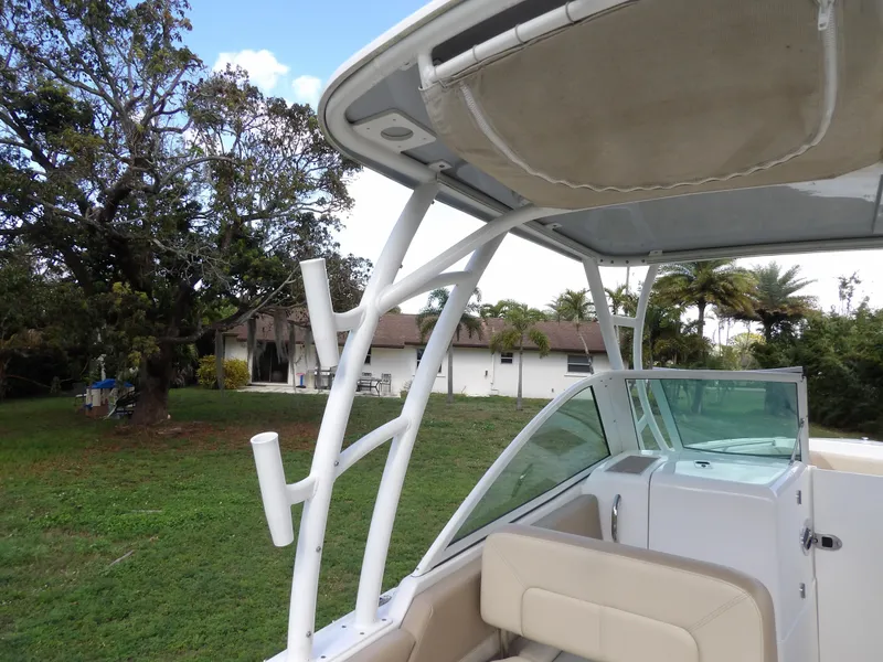 Slide: The Image of 2020 Sailfish 275 DC boat with canopy and seating, parked on grassy area. - 31