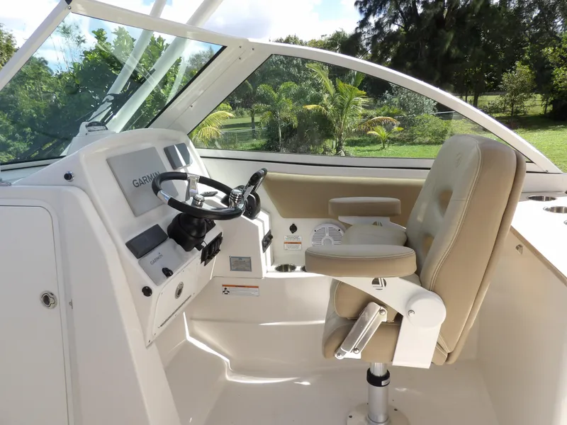 Slide: The Image of 2020 Sailfish 275 DC boat cockpit with steering wheel and captain's chair. - 35