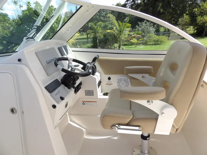 Slide: The Image of 2020 Sailfish 275 DC boat cockpit with steering wheel and beige captain's chair. - 36