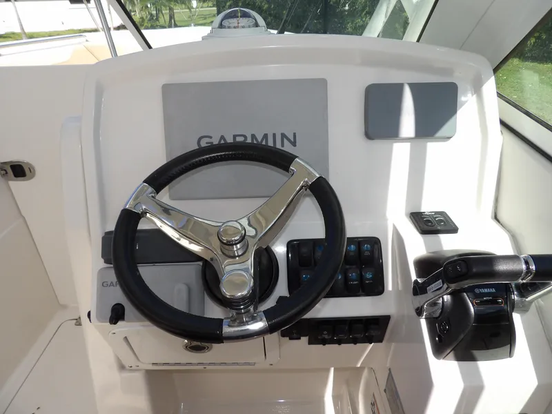 Slide: The Image of 2020 Sailfish 275 DC boat helm with Garmin navigation system and steering wheel. - 37
