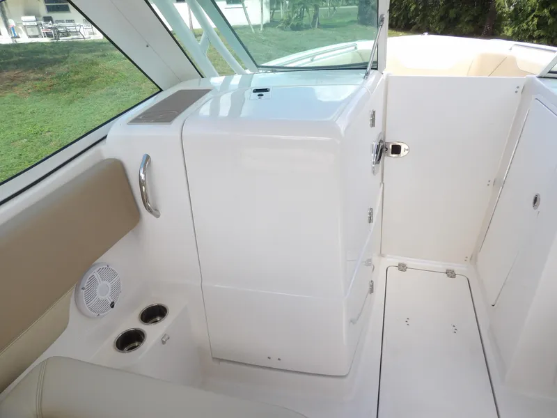 Slide: The Image of 2020 Sailfish 275 DC interior, featuring sleek white cabinetry and seating with cup holders. - 47