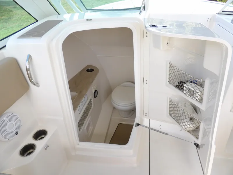 Slide: The Image of 2020 Sailfish 275 DC boat interior with compact bathroom and storage compartments. - 48