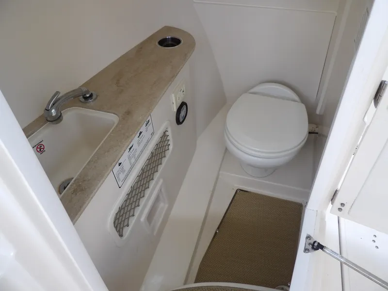 Slide: The Image of 2020 Sailfish 275 DC boat interior bathroom with sink and toilet. - 49