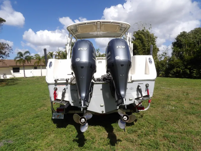 Slide: The Image of 2020 Sailfish 275 DC boat with dual 150 horsepower engines, parked on grass. - 7