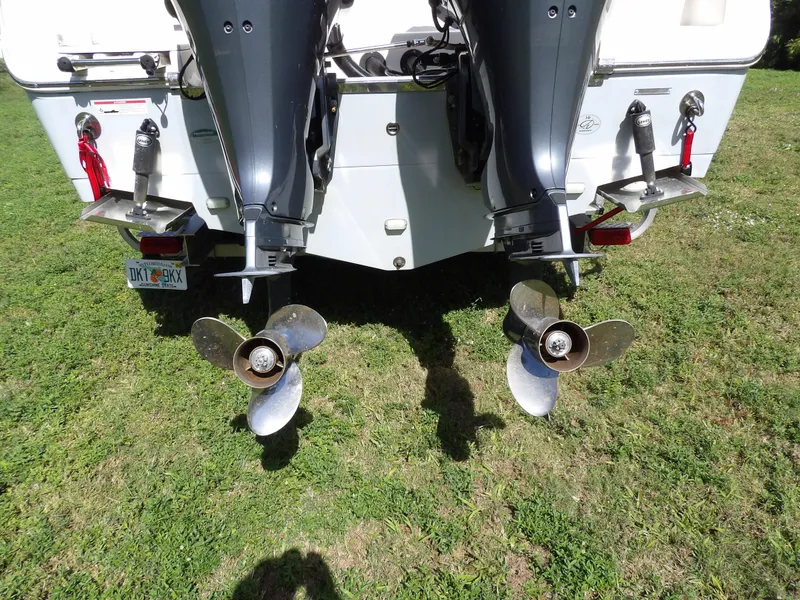 Slide: The Image of 2020 Sailfish 275 DC boat with dual outboard motors on grassy area. - 8