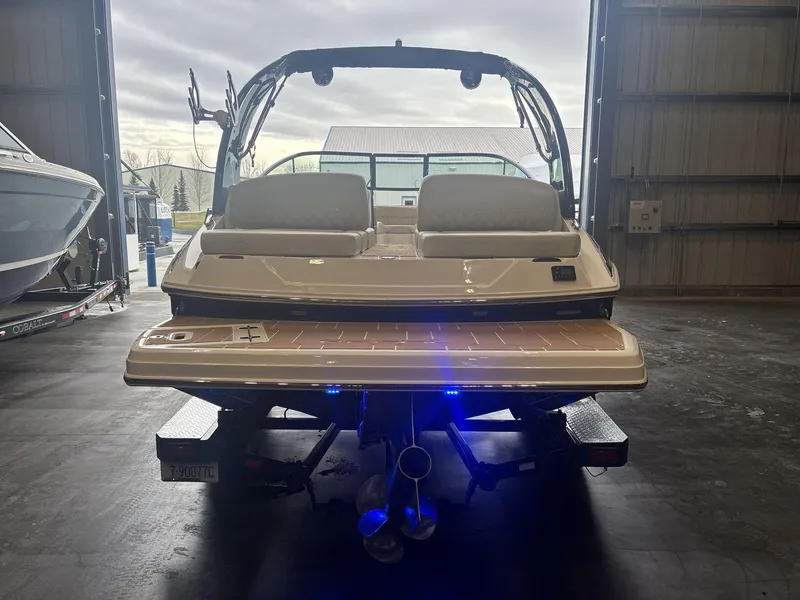 Slide: The Image of 2019 Regal 2300 RX Surf boat in a garage, rear view with trailer. - 5