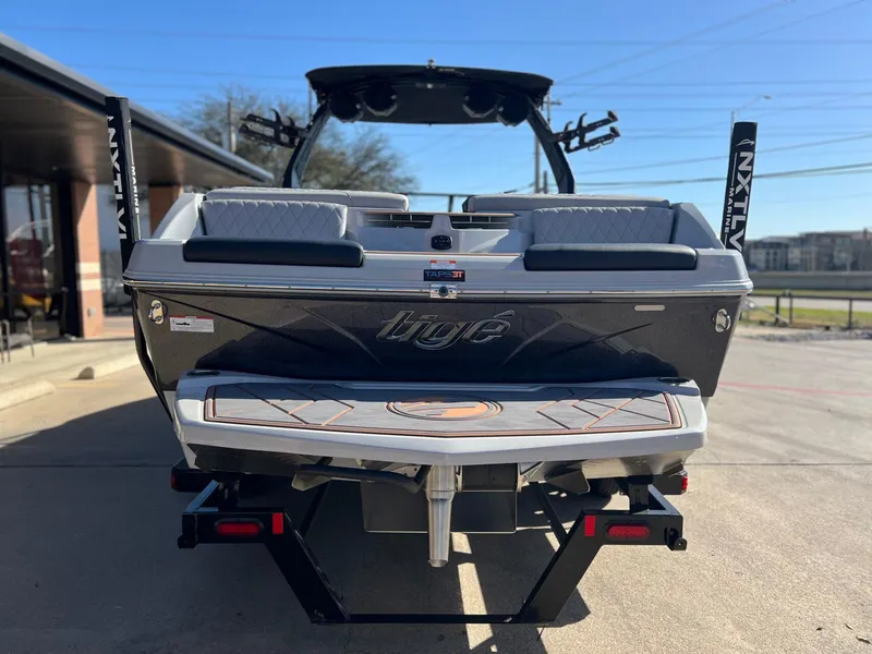Slide: The Image of 2023 Tigé Z5 boat rear view, parked on a trailer, showcasing sleek design and branding. - 4