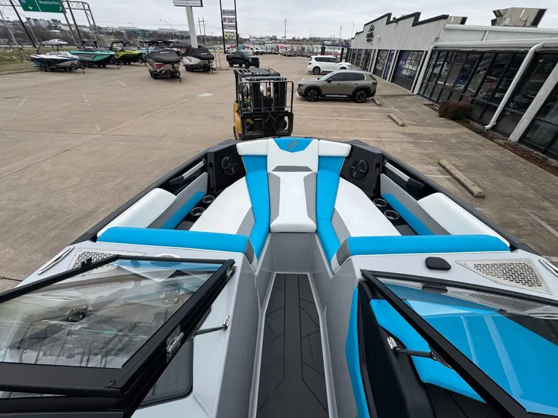 Slide: The Image of 2024 ATX Surf Boats 22 Type-S with blue and white interior, parked in a dealership lot. - 13