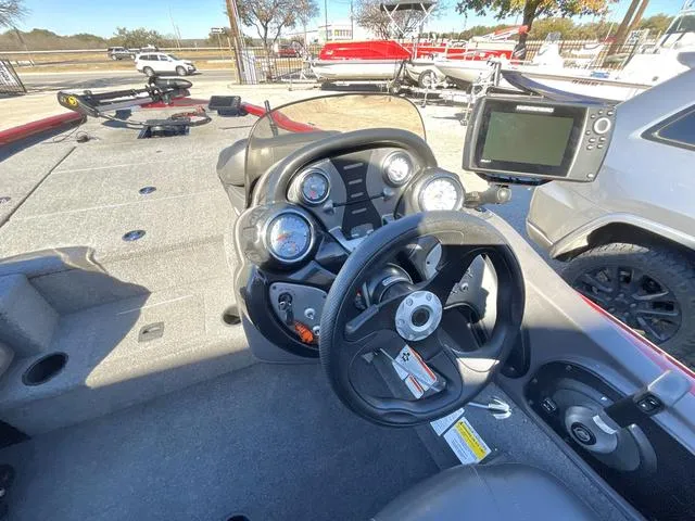 Slide: The Image of 2020 Tracker 195TXW boat dashboard with steering wheel and gauges in a marina setting. - 15