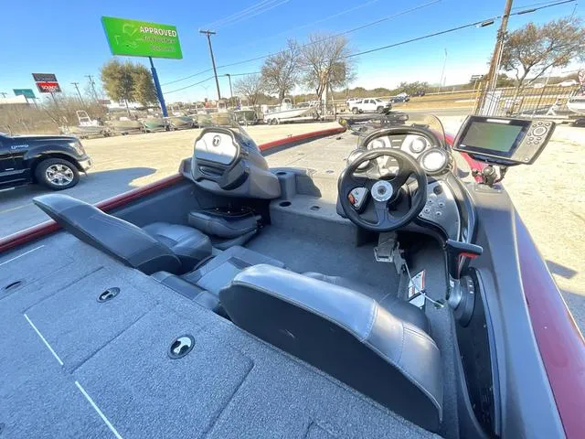 Slide: The Image of 2020 Tracker 195TXW boat interior with steering wheel and seating, parked outdoors. - 6