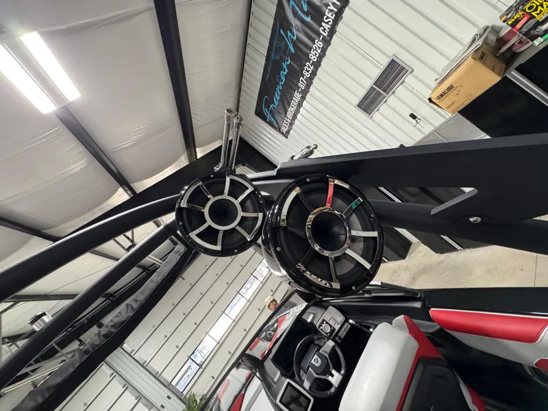 Slide: The Image of 2020 Malibu Wakesetter 22 LSV interior with speakers and seating in a garage setting. - 12