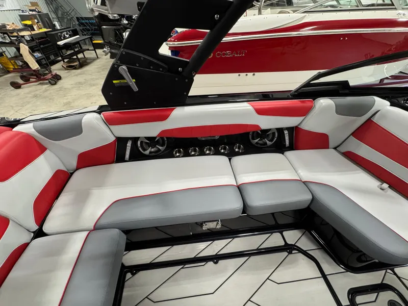 Slide: The Image of 2020 Malibu Wakesetter 22 LSV interior with red and gray seating in a workshop. - 14