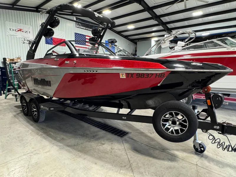 Slide: The Image of 2020 Malibu Wakesetter 22 LSV boat in a garage, red and black design. - 2