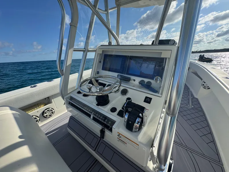 Slide: The Image of 2017 SeaVee 340Z boat console with steering wheel and navigation screens on open water. - 12