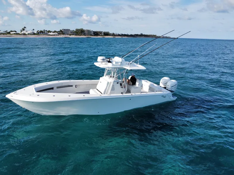 Slide: The Image of 2017 SeaVee 340Z boat on clear blue ocean water, with fishing rods and distant shoreline. - 4