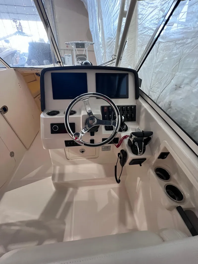 Slide: The Image of 2021 Grady-White Freedom 285 boat helm with steering wheel and control panel. - 12
