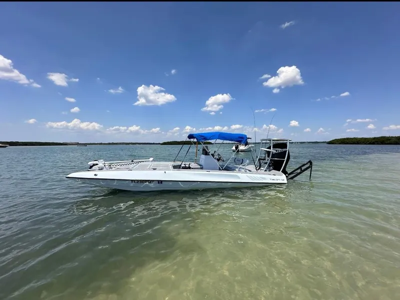 Slide: The Image of 1992 Talon F-20 boat with blue canopy on calm water under a clear sky. - 18