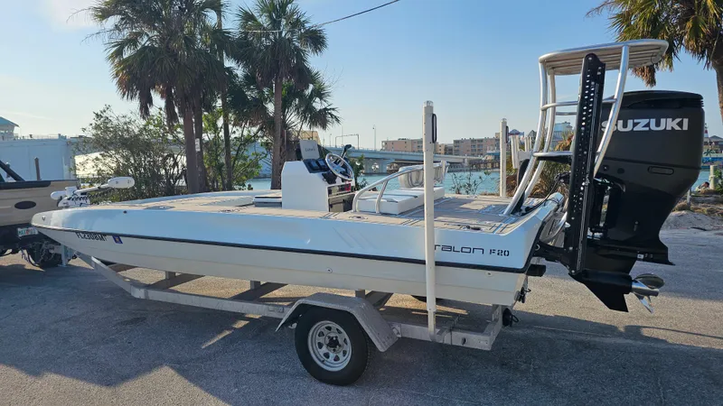 Slide: The Image of 1992 Talon F-20 boat on trailer with Suzuki outboard motor, parked near palm trees. - 2