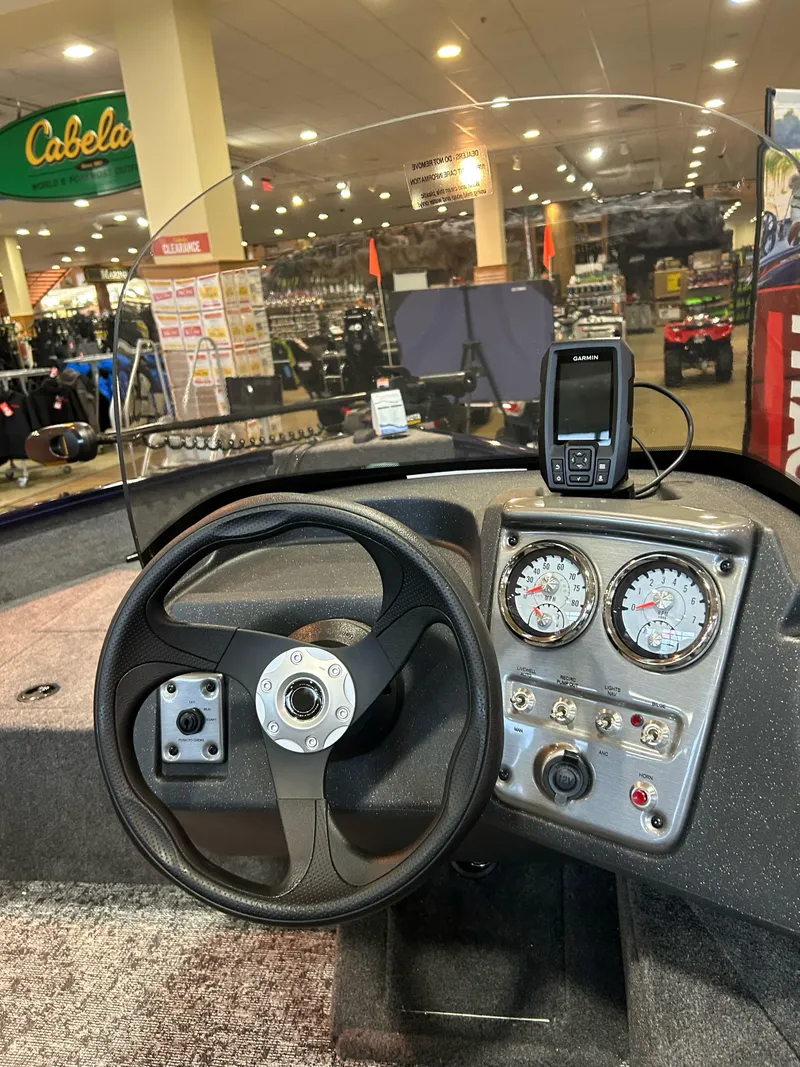 Slide: The Image of 2025 Tracker Pro Guide V-16 SC boat dashboard at Cabela's store display. - 3