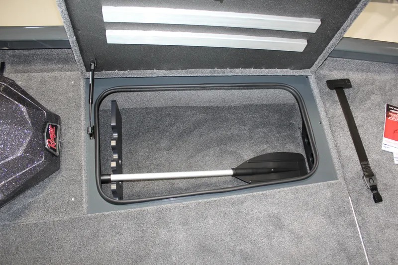 Slide: The Image of 2025 Ranger RT188P boat storage compartment with paddle and carpeted interior. - 3