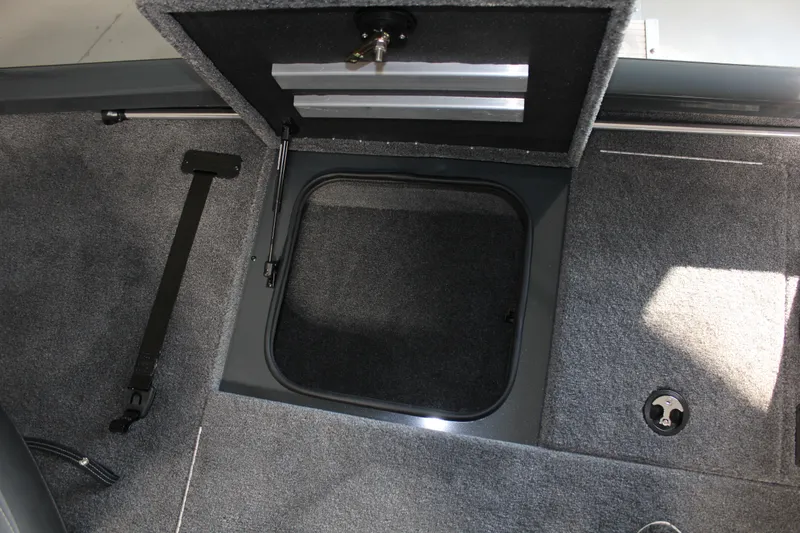Slide: The Image of 2025 Ranger RT188P boat storage compartment with open hatch and carpeted interior. - 5