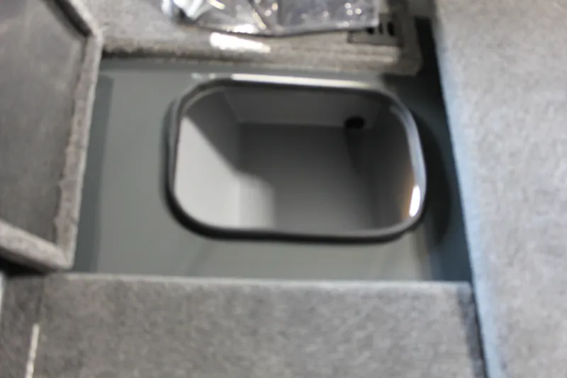 Slide: The Image of 2025 Ranger RT188P boat storage compartment with gray interior and open lid. - 6