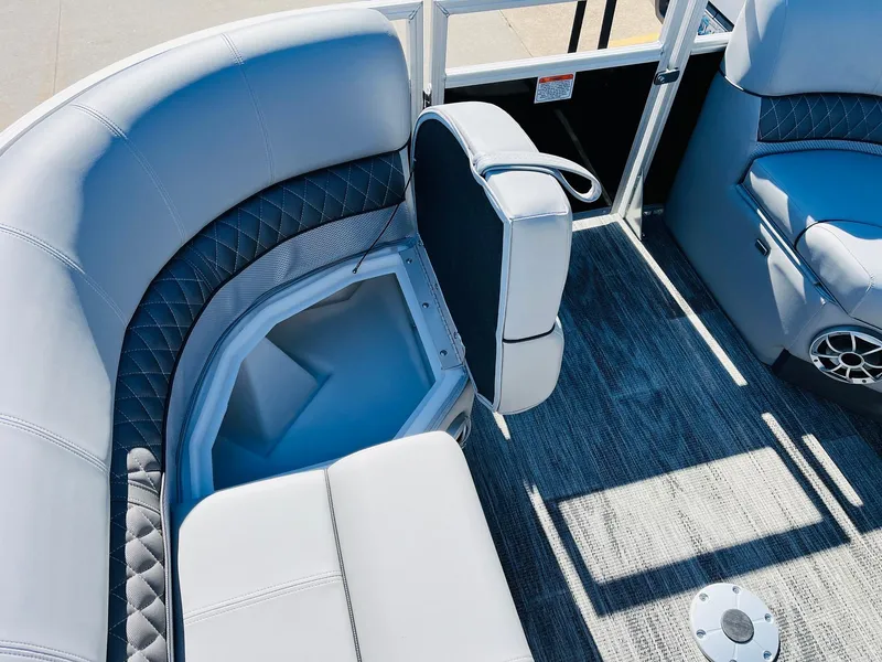 Slide: The Image of 2025 Ranger Reata 223C boat interior with gray seating and storage compartment. - 16
